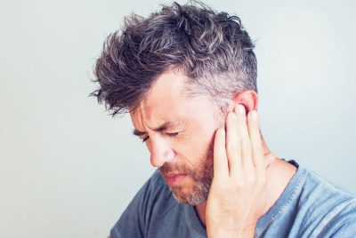 adult man with ringing in ear tinnitus
