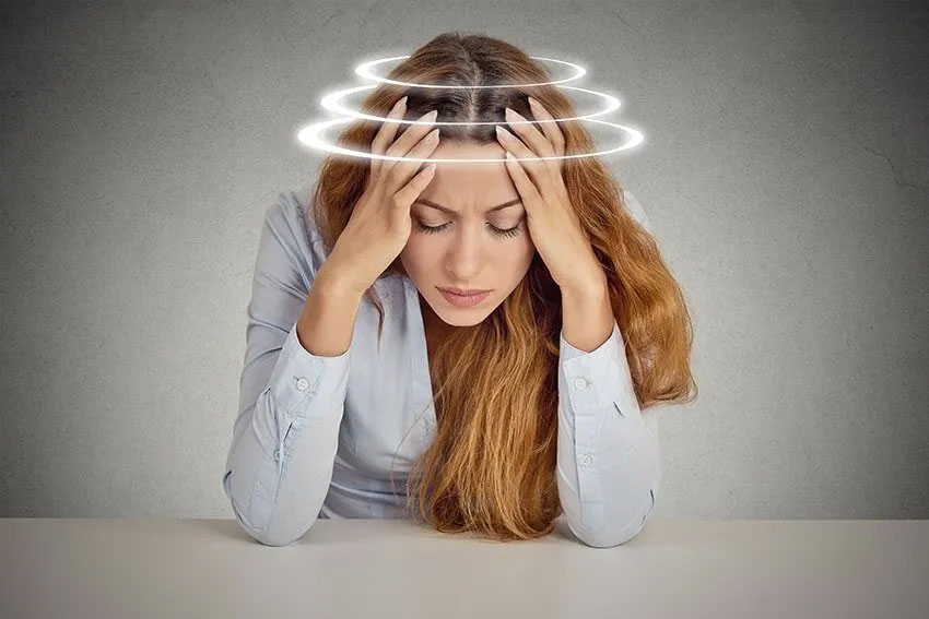 Woman experiencing dizziness and vertigo with rings around her head