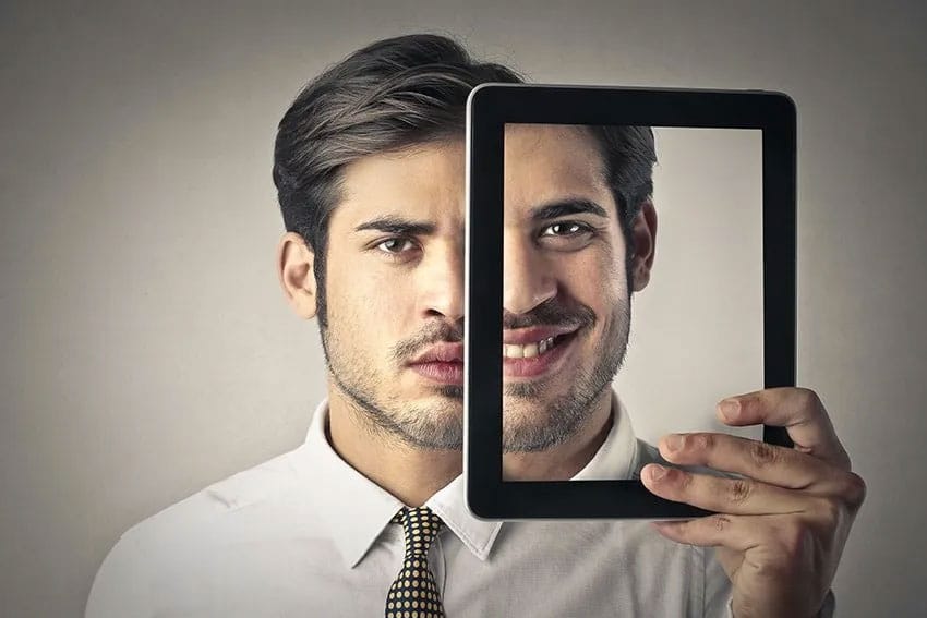 Man showing two sides to his smile with an Ipad screen