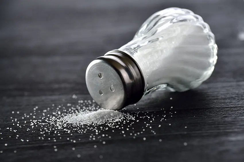 jar of salt spilling out on a table top