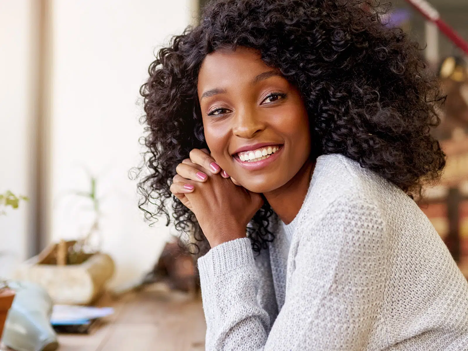 Woman smiling at her desk in front of the window