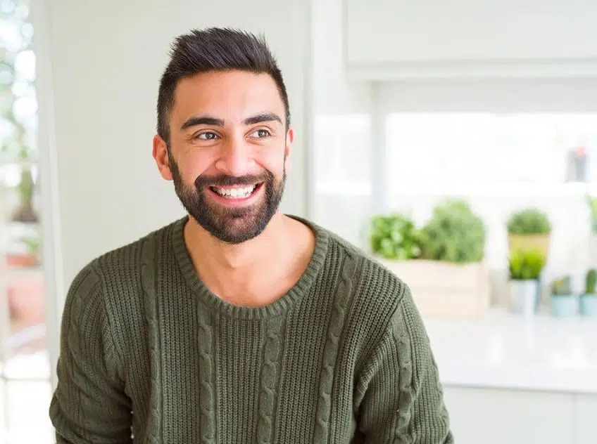 Younger man with short, dark hair, green shirt, and beard smiling